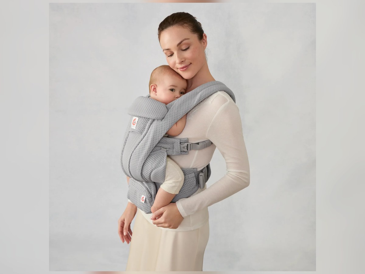 Elternteil trägt ein Baby in einer Ergobaby Babytrage