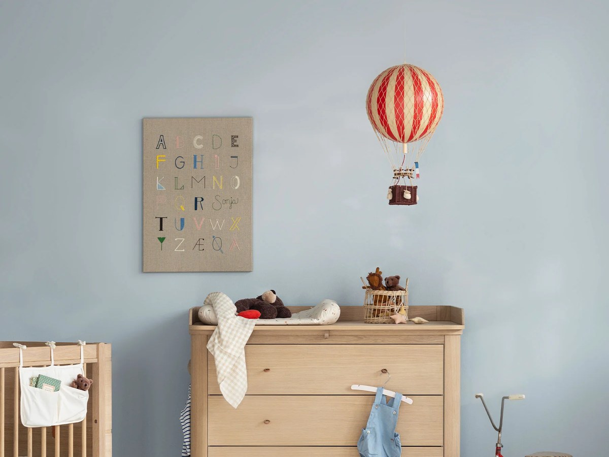 Liebevoll eingerichtetes Babyzimmer mit Bett, Wickelkommode und Spielbereich